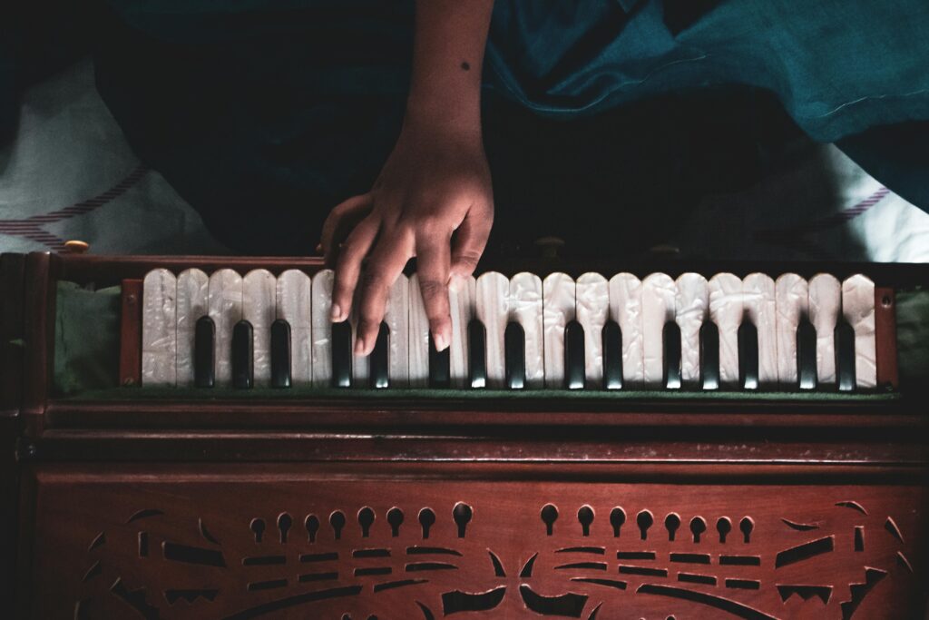 A hand playing a wooden harmonium, showcasing musical artistry.